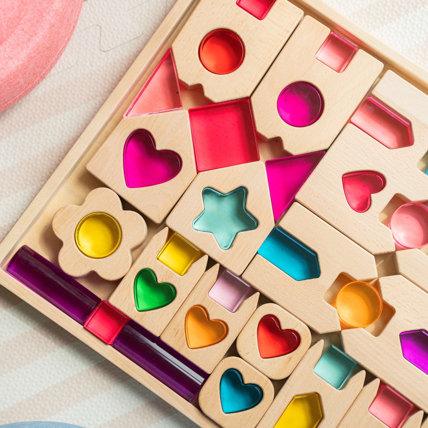Colorful wooden block set with various shapes on a light surface