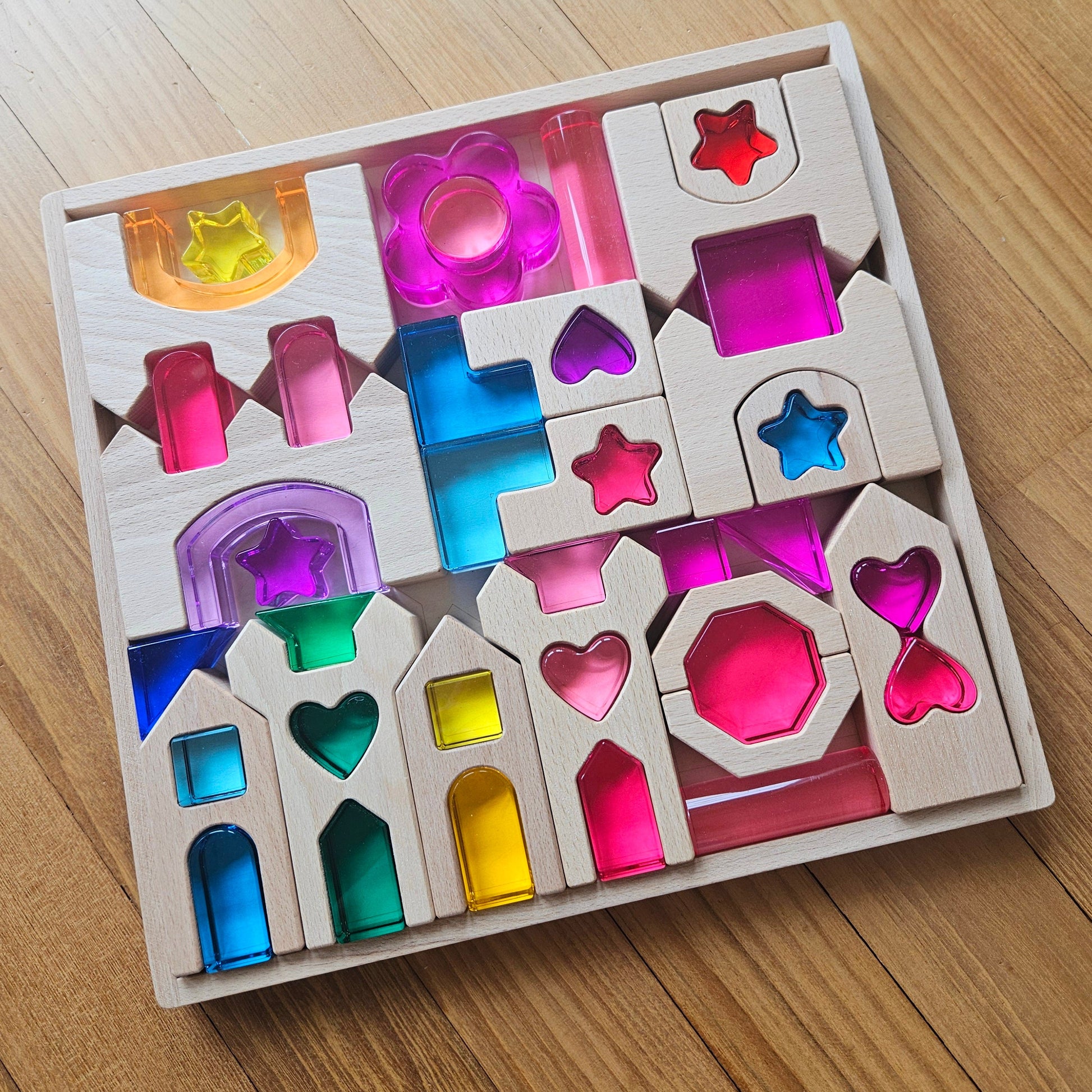 Star of the Lucite Kingdom set with lucite hearts, stars and arches beside wooden castle blocks in an engraved tray