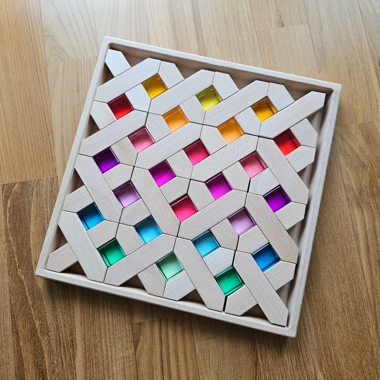 X-shaped beechwood blocks and rainbow lucite cubes in an engraved tray